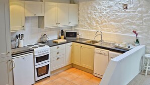 A kitchen with white cabinets, a stove, oven, microwave, and dishwasher. - 2 bedroom accommodation in Godolphin Cross, Helston (Godolphin Cross, Helston)