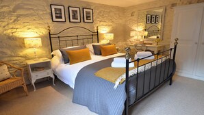 A bedroom with a bed, nightstands, a chair, and a wardrobe. - 2 bedroom accommodation in Godolphin Cross, Helston (Godolphin Cross, Helston)