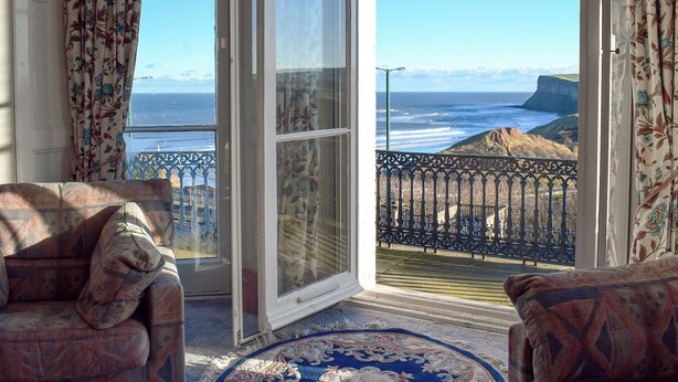 A room with a view of the ocean and cliffs, a patterned rug, and two patterned sofas. - 2 bedroom accommodation in Saltburn-by-the-Sea (Saltburn-by-the-Sea)