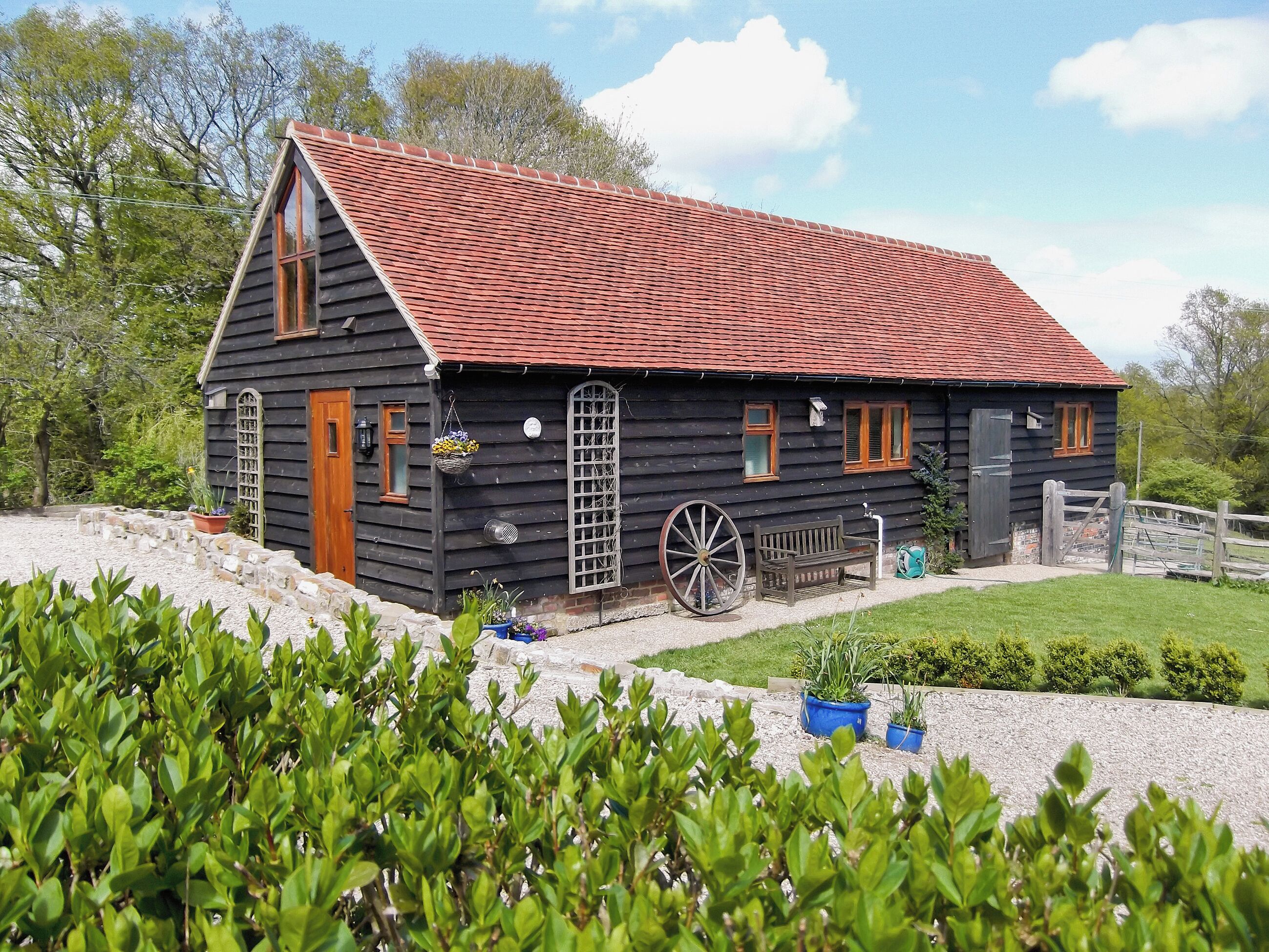 Une maison en bois avec un toit rouge, une porte en bois et une fenêtre.