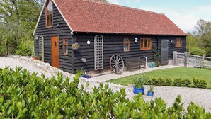 Une maison en bois avec un toit rouge, une porte en bois et une fenêtre.