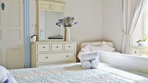 A neatly arranged bedroom with a bed, a dresser, a mirror, and a window with curtains. - 3 bedroom accommodation in Instow, Bideford (Instow, Bideford)