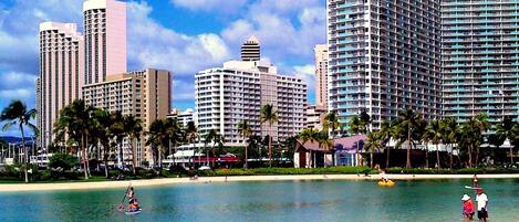 A beachfront hotel with multiple high-rise buildings, palm trees, and a clear sky.