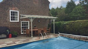 A brick house with a pool, outdoor furniture, and a pergola. - Greenlands Farmhouse (Barmby Moor, York)