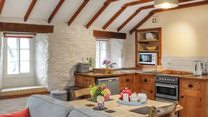 Una cocina acogedora con armarios de madera, una mesa de comedor con sillas y un horno empotrado.