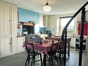 Une cuisine avec une table à manger, des chaises et une vue sur l’extérieur.