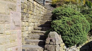 A stone staircase with a metal railing, surrounded by greenery. - 1 bedroom accommodation in Baslow, near Bakewell (Baslow, near Bakewell)