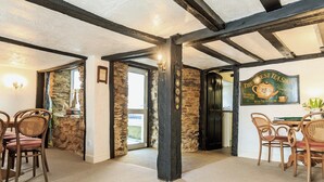 A rustic interior with exposed beams, stone walls, and a tea shop sign. - 7 bedroom accommodation in West Pentire (West Pentire)
