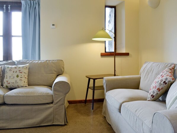 A living room with two sofas, a small table, and a floor lamp. - 2 bedroom accommodation in Tregarth, near Bangor (Tregarth, near Bangor)