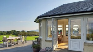 Une maison dotée d’un patio, d’un coin repas et offrant une vue sur la campagne.
