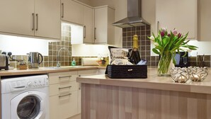 Una cocina moderna con lavadora integrada, cocina a gas y microondas.