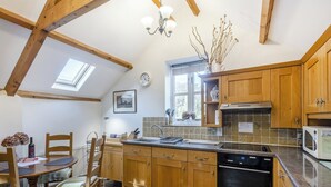 Una cucina con mobili in legno, lavastoviglie, forno a microonde e una finestra con vista.