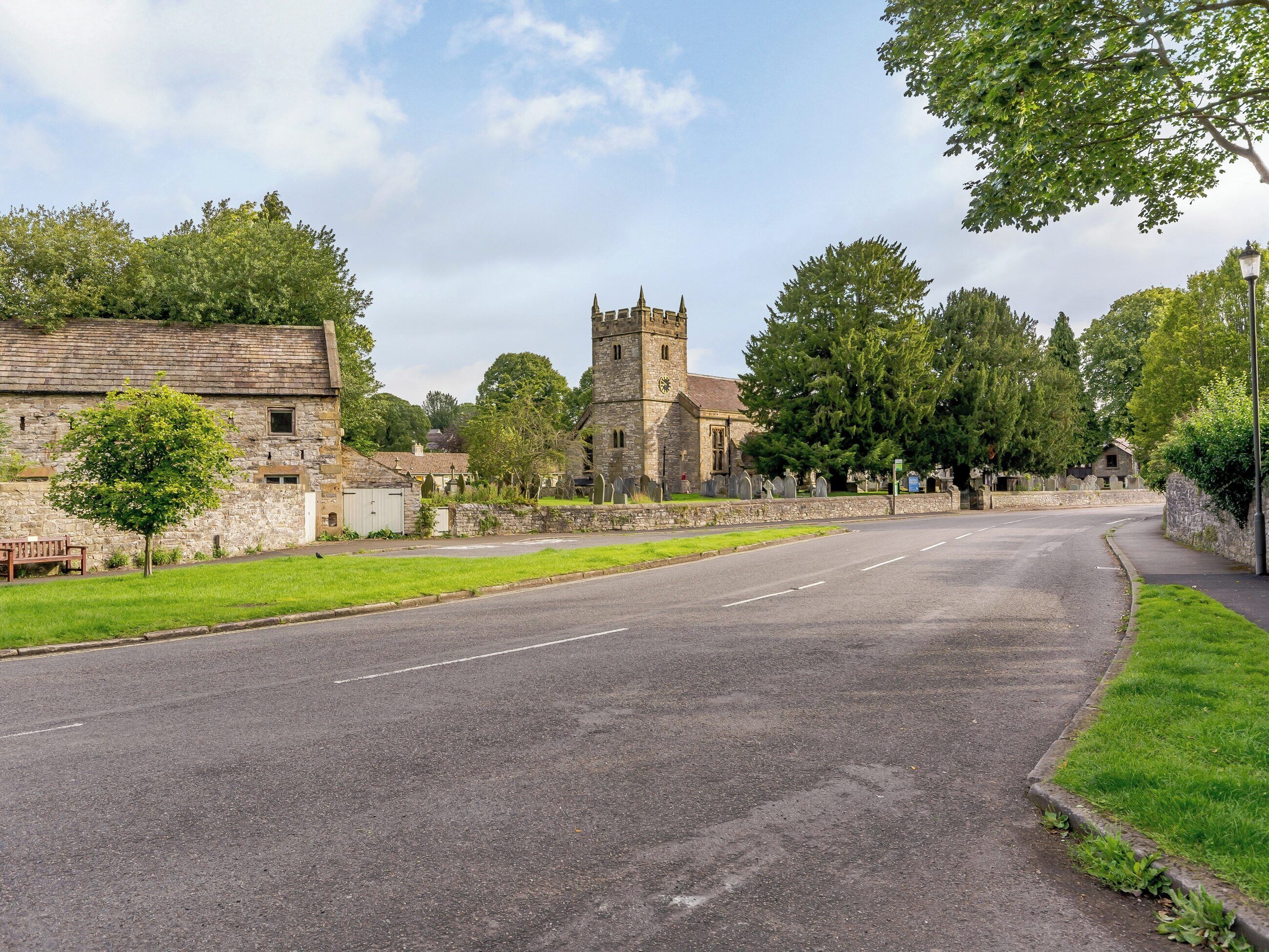 A quiet street with a church and stone buildings.