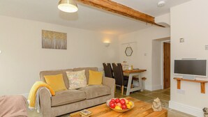 A cozy living room with a sofa, coffee table, and a dining area with chairs and a table. - 3 bedroom accommodation in Ashford-in-the-Water, near Bakewell (Ashford-in-the-Water, near Bakewell)