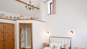 A bedroom with a bed, bedside tables, a wardrobe, a shower, and a chandelier. - 3 bedroom accommodation in Alwington, near Bideford (Alwington, near Bideford)