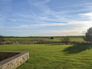 A rural landscape with a stone wall, a wooden fence, and a grassy field under a clear sky. - 3 bedroom accommodation in Bamburgh (Bamburgh)