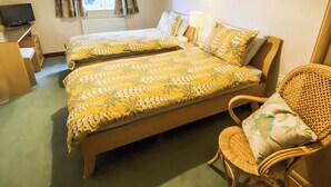 A hotel room with two beds, a chair, a desk, and a television. - 3 bedroom accommodation in Bamburgh (Bamburgh)