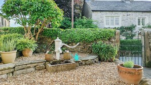 A garden with pebbles, a water fountain, and potted plants. - 1 bedroom accommodation in Giggleswick, near Settle (Giggleswick, near Settle)