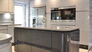 A modern kitchen with stainless steel appliances, a granite countertop, and a built-in oven.