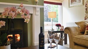 Una sala de estar acogedora con chimenea, una mesa con revistas y un sofá.