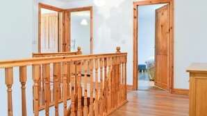 Una escalera de madera con barandilla que sube a un segundo piso.