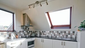 A modern kitchen with white cabinets, a microwave, a kettle, and a sink. - 1 bedroom accommodation in Upton (Upton)