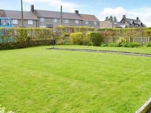 A residential area with a well-maintained lawn, a wooden fence, and houses in the background. - 3 bedroom accommodation in Shilbottle, near Alnwick (Shilbottle, near Alnwick)