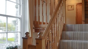 Una scala con balaustre in legno e un pianerottolo rivestito di moquette.