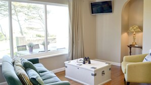 A living room with a sofa, a coffee table, a television, and a lamp. - 2 bedroom accommodation in Aberystwyth (Aberystwyth)