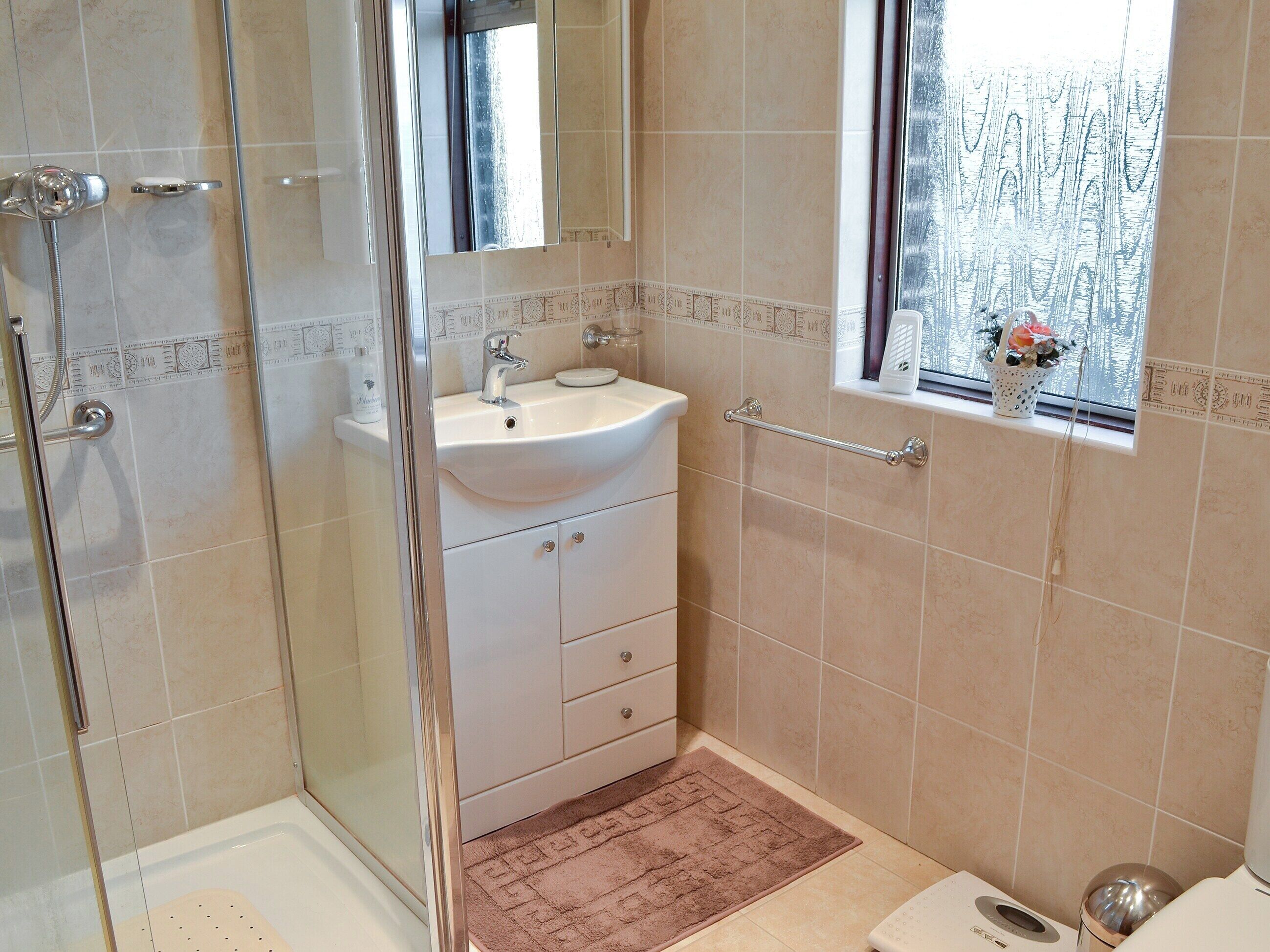 Une salle de bain avec une douche, un lavabo et des toilettes.