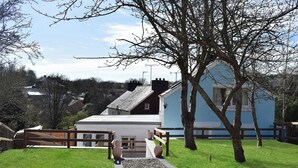 A residential property with a paved pathway, a wooden fence, and a blue house with a sloped roof. - 3 bedroom accommodation in Llanarth, near New Quay (Llanarth, near New Quay)