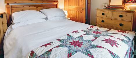 Ein Schlafzimmer mit einem hölzernen Bett, einem Schminktisch und einer Tür.