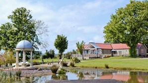 A gazebo, a wooden dock, and a house with a red roof. - 4 bedroom accommodation in Killerby, near Scarborough (Killerby, near Scarborough)
