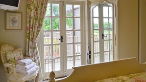 A room with a bed, a chair with a stack of towels, a television, and a window with a view of the outside. - 4 bedroom accommodation in Killerby, near Scarborough (Killerby, near Scarborough)