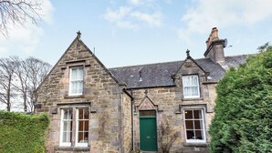 A stone house with a green door, two windows on the ground floor, and a chimney. - 2 bedroom accommodation in Keith (Keith)