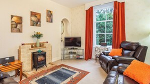 A living room with a fireplace, leather sofa, and a television. - 2 bedroom accommodation in Keith (Keith)