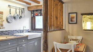 A kitchen with grey cabinets, a wooden countertop, and a window with a view.