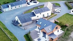 A modern house with a large driveway, a garage, and a small outdoor seating area. - Felin Hedd (Peaceful Mill) (Tregaron, near Aberystwyth)