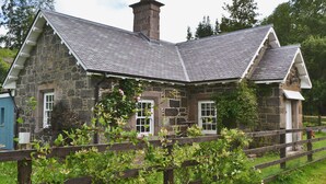 Ein Haus aus Stein mit einem Satteldach und einem Schornstein.