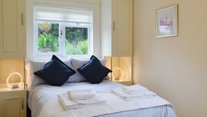 A bedroom with a bed, two bedside lamps, a window with blinds, and a framed picture on the wall. - 3 bedroom accommodation in Llangenny, near Crickhowell (Llangenny, near Crickhowell)