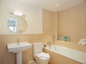A bathroom with a sink, toilet, and bathtub.