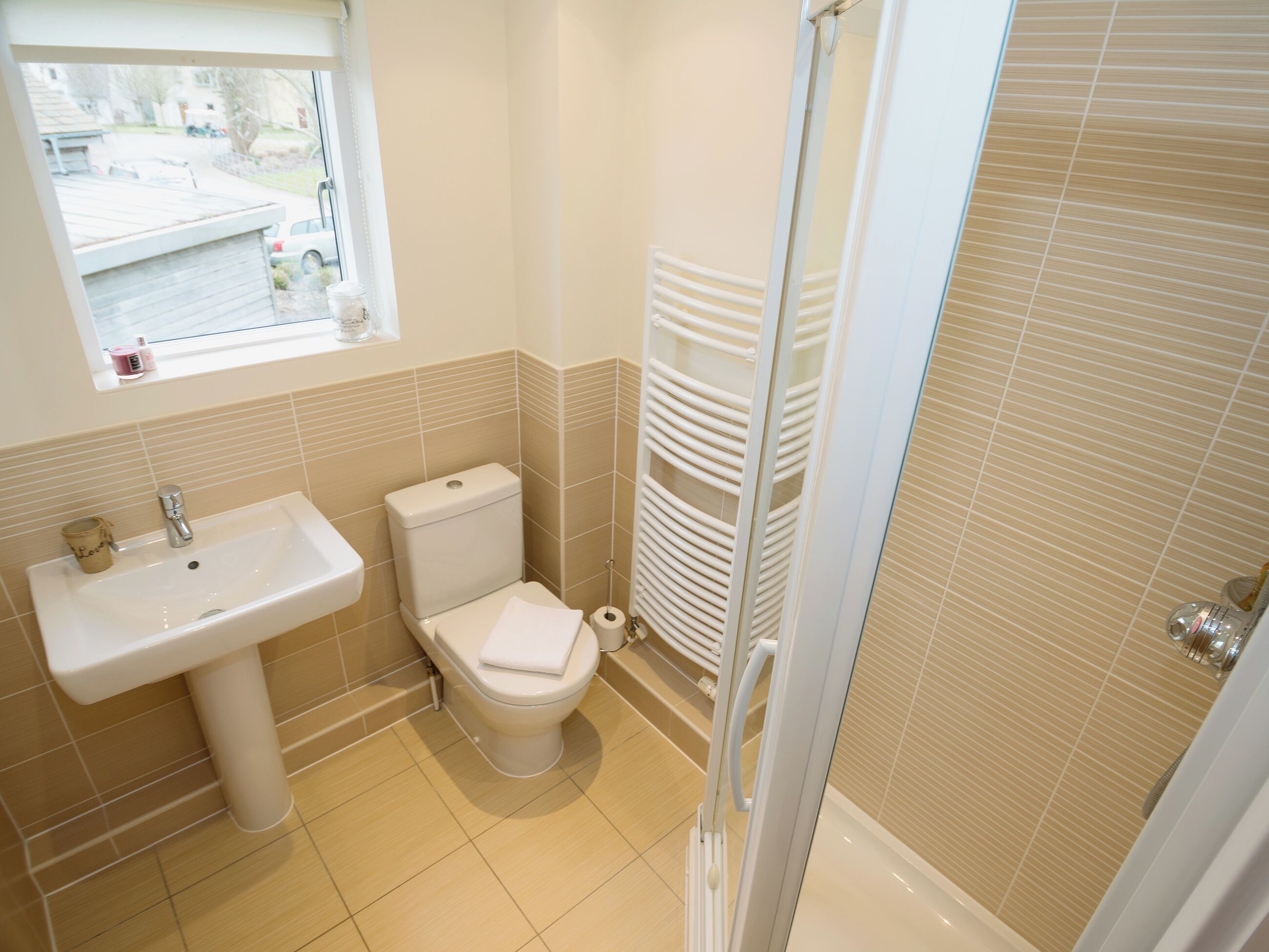 A bathroom with a toilet, sink, and shower.