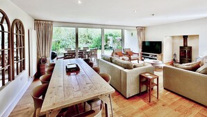 Un amplio salón con una mesa de comedor de madera, un sofá y una televisión.