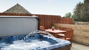A hot tub with water flowing, surrounded by wooden furniture and a wooden deck. - 2 bedroom accommodation in Longdyke, near Morpeth (Longdyke, near Morpeth)