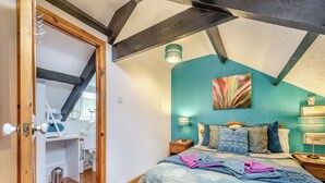 A bedroom with a bed, a nightstand, a lamp, and a wall-mounted heater. - 0 bedroom accommodation in Gowerton, Gower (Gowerton, Gower)