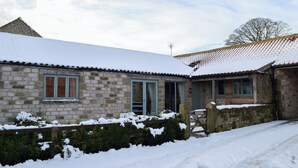A stone building with a snow-covered roof and a wooden gate. - 3 bedroom accommodation in Spaunton, near Lastingham (Spaunton, near Lastingham)