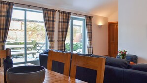 A dining area with a wooden table, a large bowl, and a blue sofa. - 3 bedroom accommodation in Spaunton, near Lastingham (Spaunton, near Lastingham)
