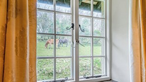 A window with a view of a grassy area and trees. - Granary Cottage - E5634 (Chittlehampton, near Umberleigh)