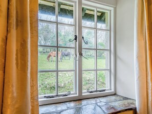 A window with a view of a grassy area and trees. - Granary Cottage - E5634 (Chittlehampton, near Umberleigh)