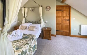 A bedroom with a canopy bed, a wooden door, and a radiator.